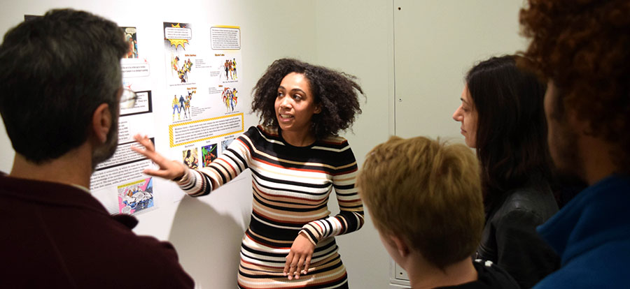 A student shows their work during a gallery talk