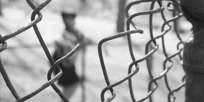 an out of focus person viewed through a chainlink fence