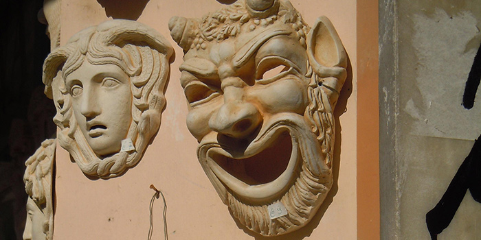 Classical tradgedy and comedy masks hanging on a wall
