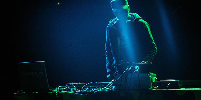 a DJ on stage with computer equipment