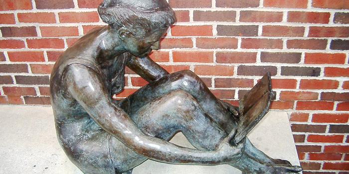statue of a child reading a book