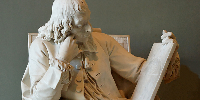 Statue of a scholar studying a tablet