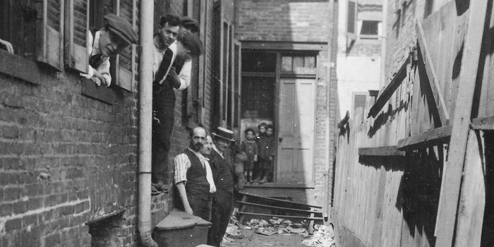 historic photo of working class people in an alleyway