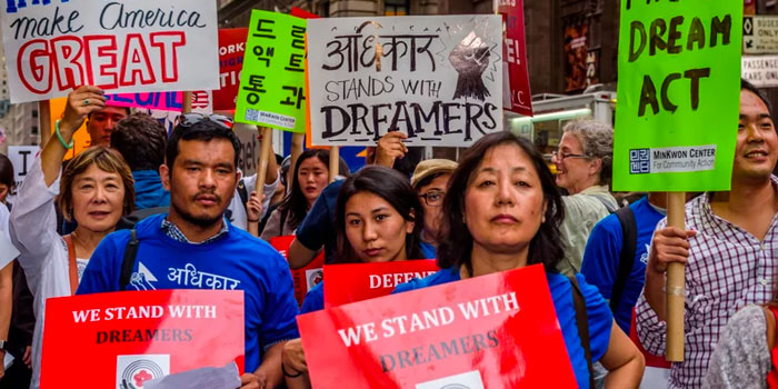 People hold signs in support of dreamers while marching in a protest