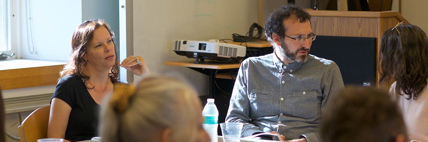 Faculty sit around a table deep in discussion during a working group meeting