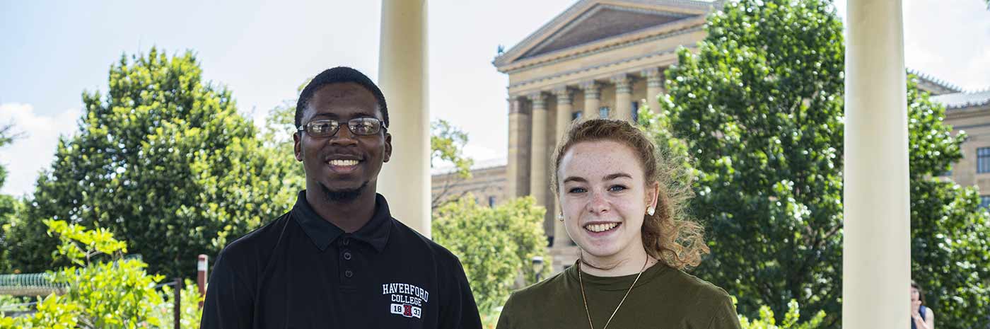 two students pose with the Philadelphia Museum of Art visible in the background