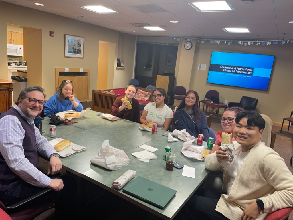 Students and staff sharing sub sandwiches at a Graduate and Professional School dinner