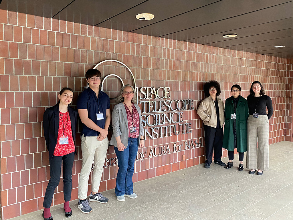 Maša (Masha) Kilibarda ’26 and others standing outside a brick wall with the words Space Telescope Science Institute