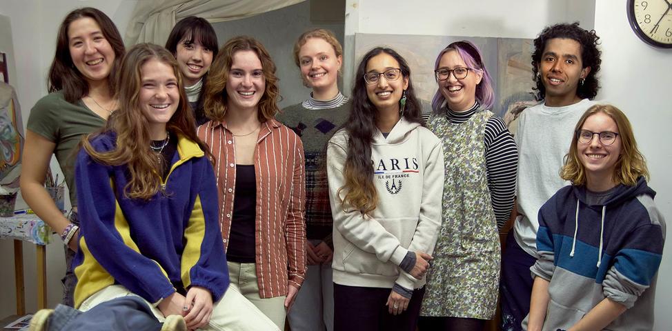 Nine Fine Arts seniors smiling for the camera in a studio