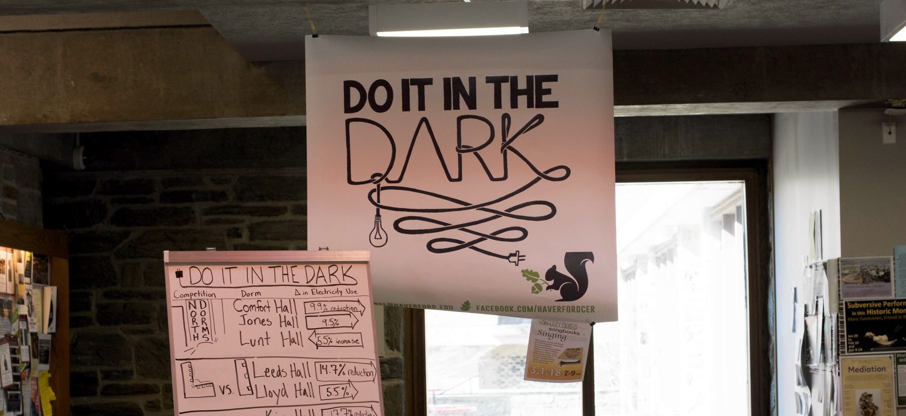 A Do It In The Dark banner hanging in the Dining Center