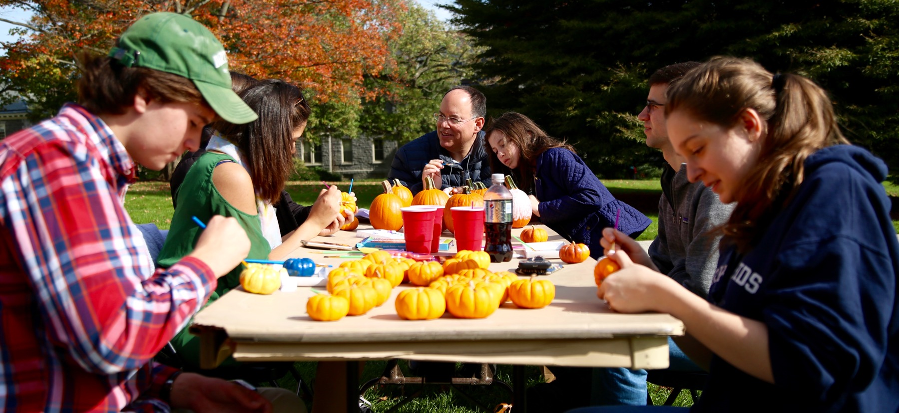 Family at table painting pumpkins