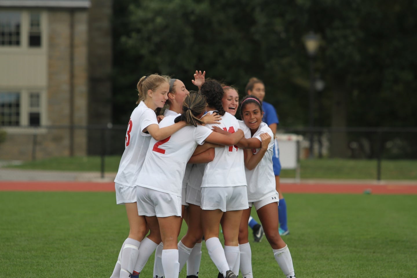 A group of soccer players celebrate in a huddle
