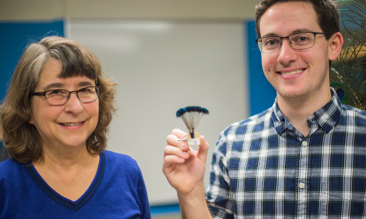 Suzanne Amador Kane and Daniel Van Beveren pose with one of their robotic feathers from their experiment.
