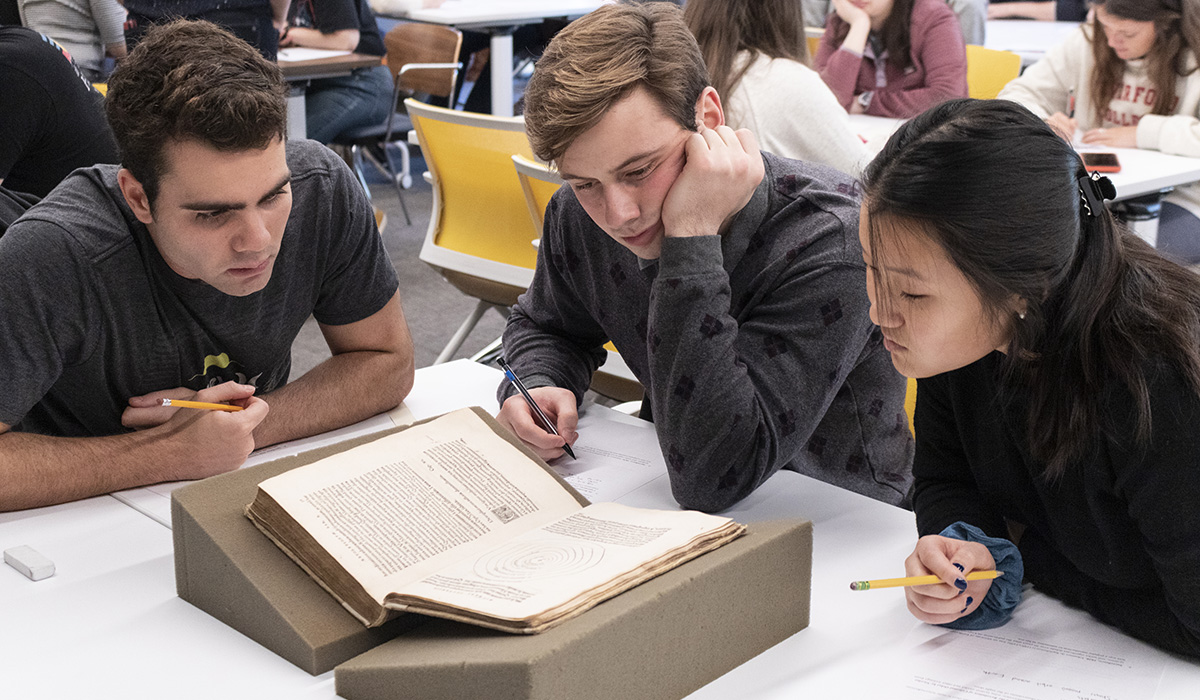 Students from Karen Master's "Astronomical Ideas" examine Nicolaus Copernicus’s De Revolutionibus (1543), the first book to present the sun-centered theory of the universe. Photo: Emily Williams '20