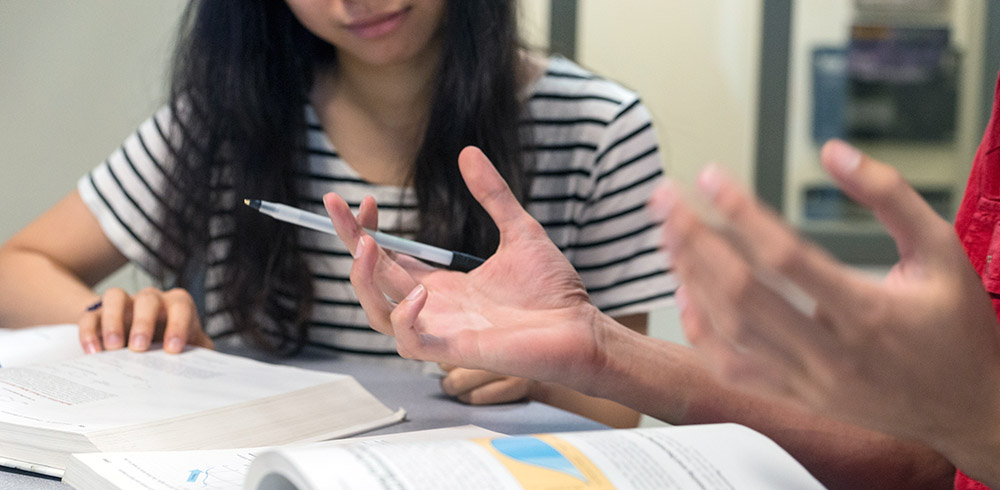 Close up on hands illustrating a point during a tutoring session