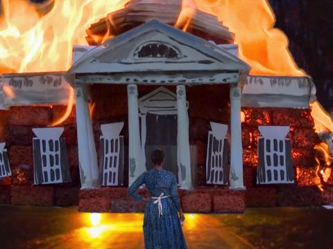Marisa Williamson performs as Sally Hemings on the winter grounds of Monticello, a simulated version of the building burning in front of her: she is a woman of the past and the present