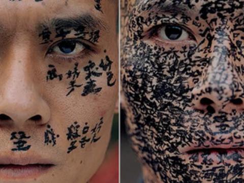 Two faces with Asian caligraphy painted on them.
