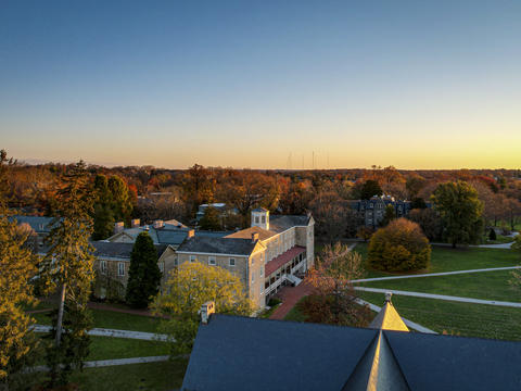 A drone photo taken of Founders Hall from the side at sunset in autumn