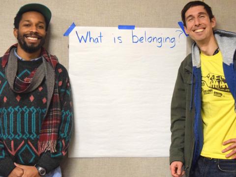 Sterling Duns and Caselli Jordan stand in front of a large piece of paper asking what "belonging" is