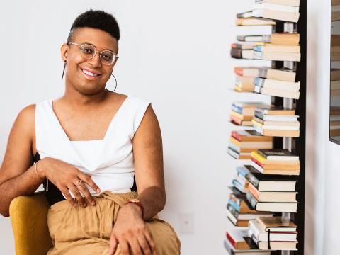 Denne Michele Norris sits in her home office next to bookshelves full of books. 