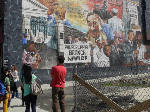 Group of students view one of Philadelphia's murals.