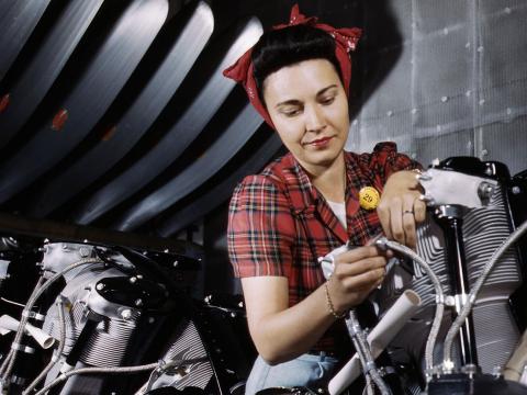 a WWII-era woman working on a motorcycle