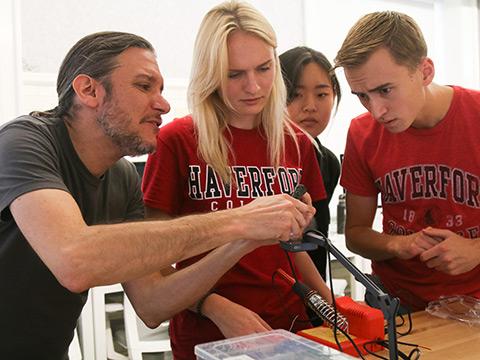 Students and an instructor examine an object together