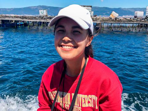 Annemarie Wood '23 sits on a boat at Spain's Bottlenose Dolphin Research Institute, smiling.