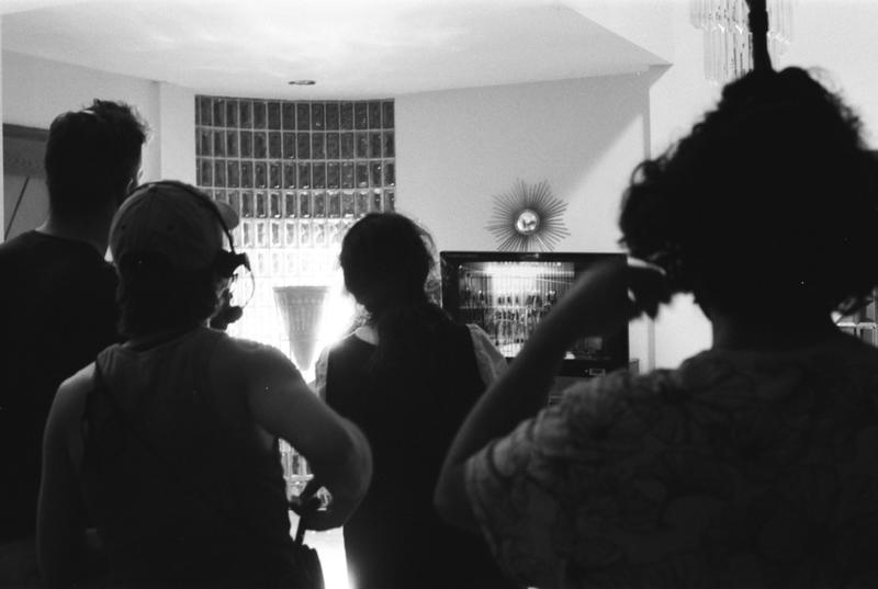 Black and white image of filmmakers crowded around the "video village."