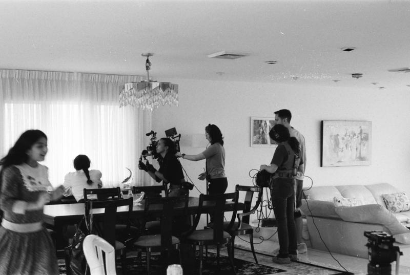 Black and white image of Khaula's crew filming a scene in a living room