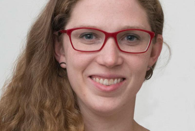 A close-up portrait of Katharine Storr '08, wearing red glasses