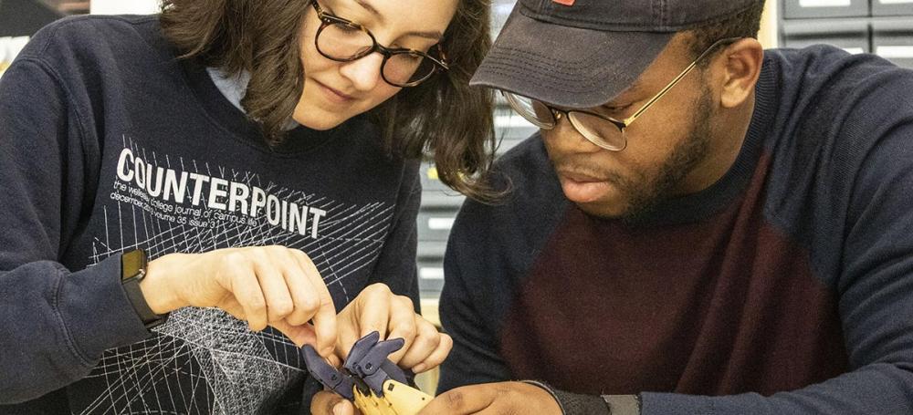 Two students work together to assemble a prosthetic