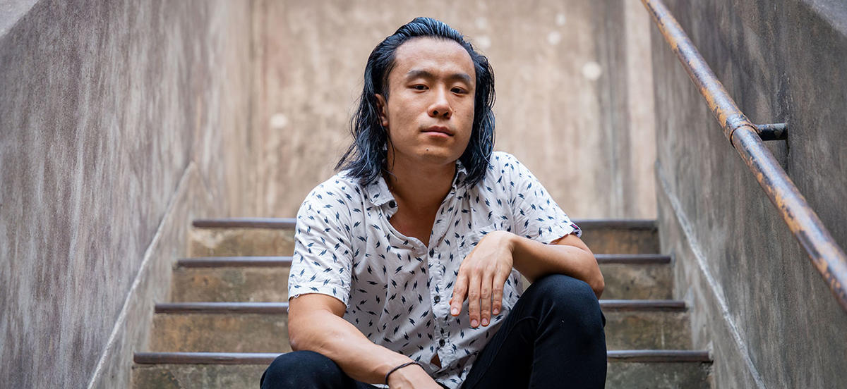Alex Wang '17 sits for a portrait on a set of concrete steps