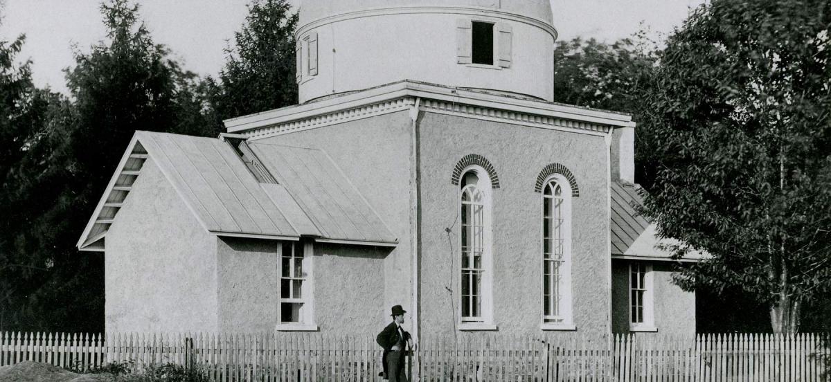 A photo of a man standing in front of an observatory
