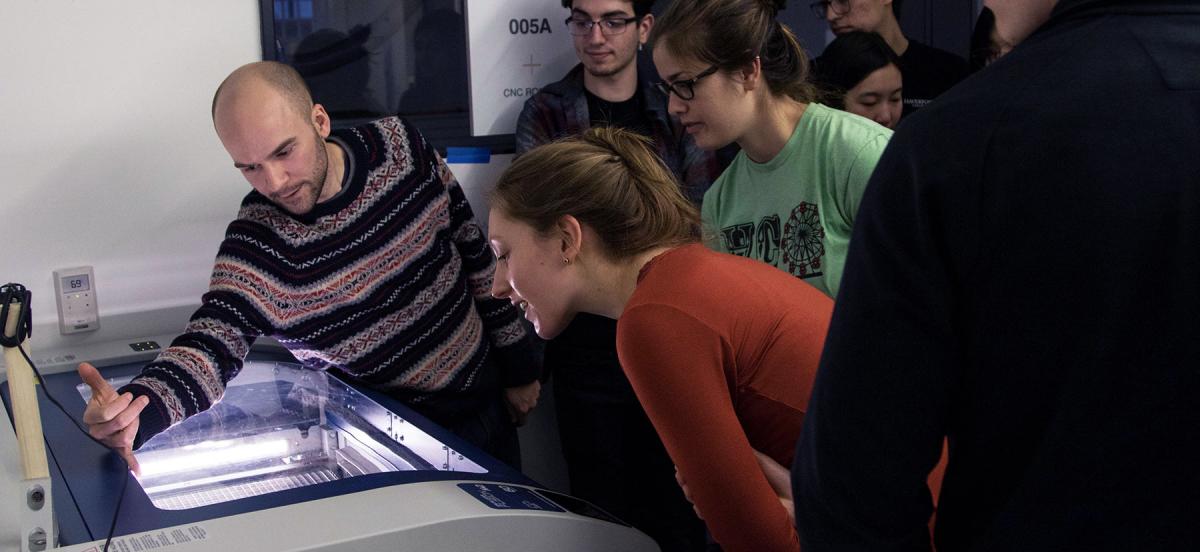 A group examines a large laser cutter