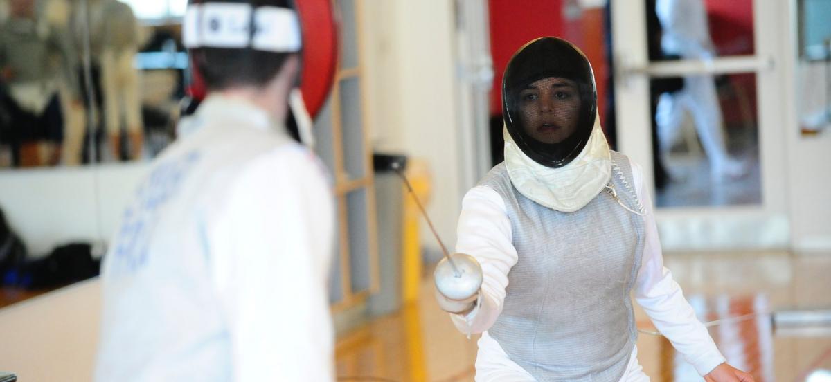 Woman competing in fencing match