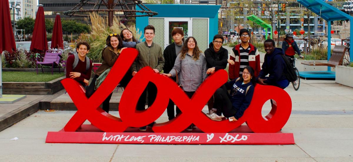 A group of students pose behind a sculpture in Philadelphia
