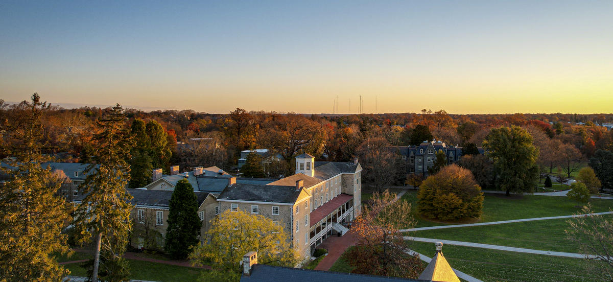 A drone photo taken of Founders Hall from the side at sunset in autumn