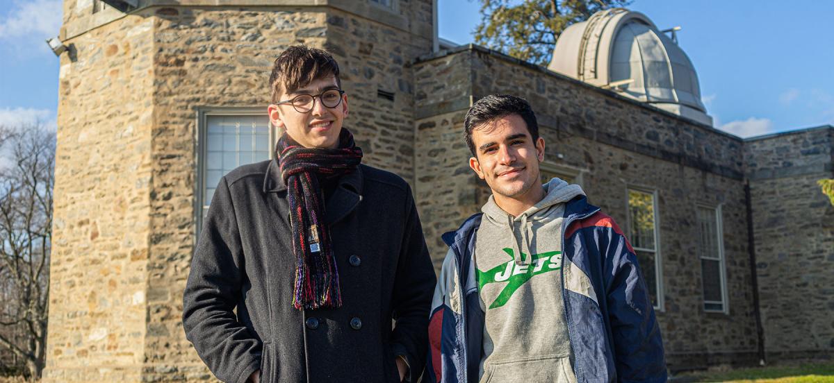 Jesse Zeldes and Sergio Montano stand in front of the on-campus observatory