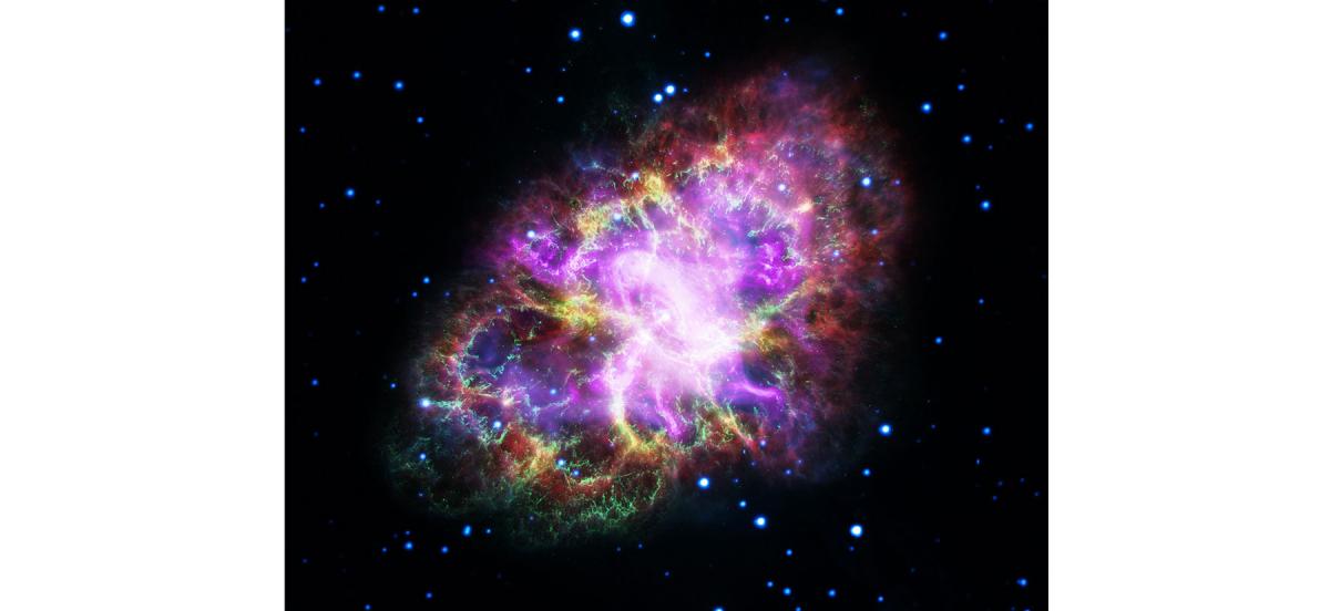 A brilliant ball of purple, green, and yellow light that is the Crab Nebula, shown as X-ray, ultraviolet, infrared, and visible light