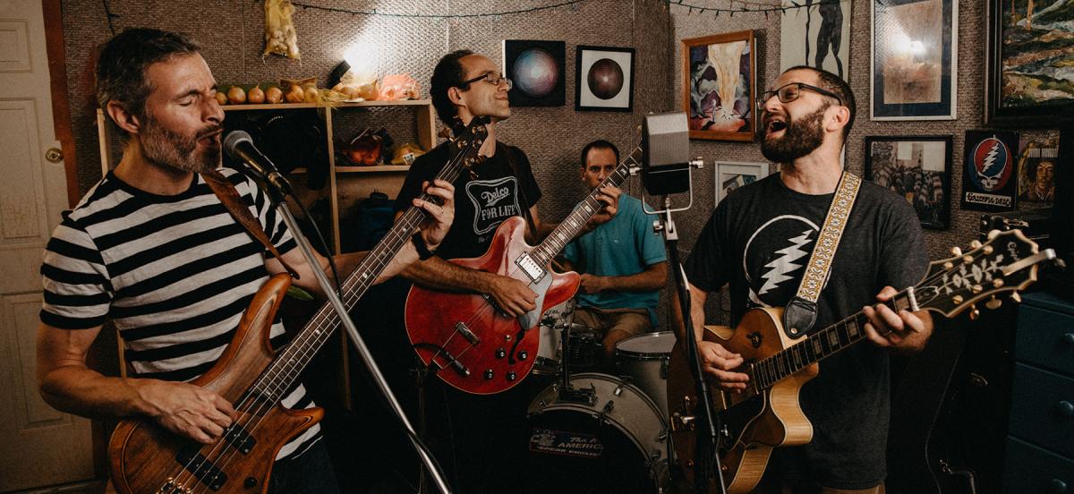 The band jams together in their practice space