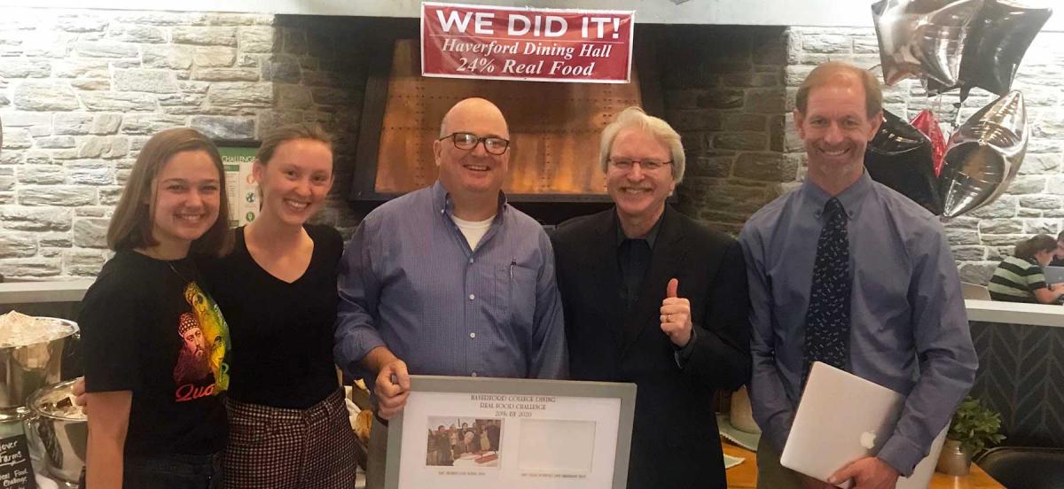 Students, Tom Mitchell, President Benston, and Jesse Lytle with a plaque acknowledging Haverford making its Real Food Challenge in the Dining Center