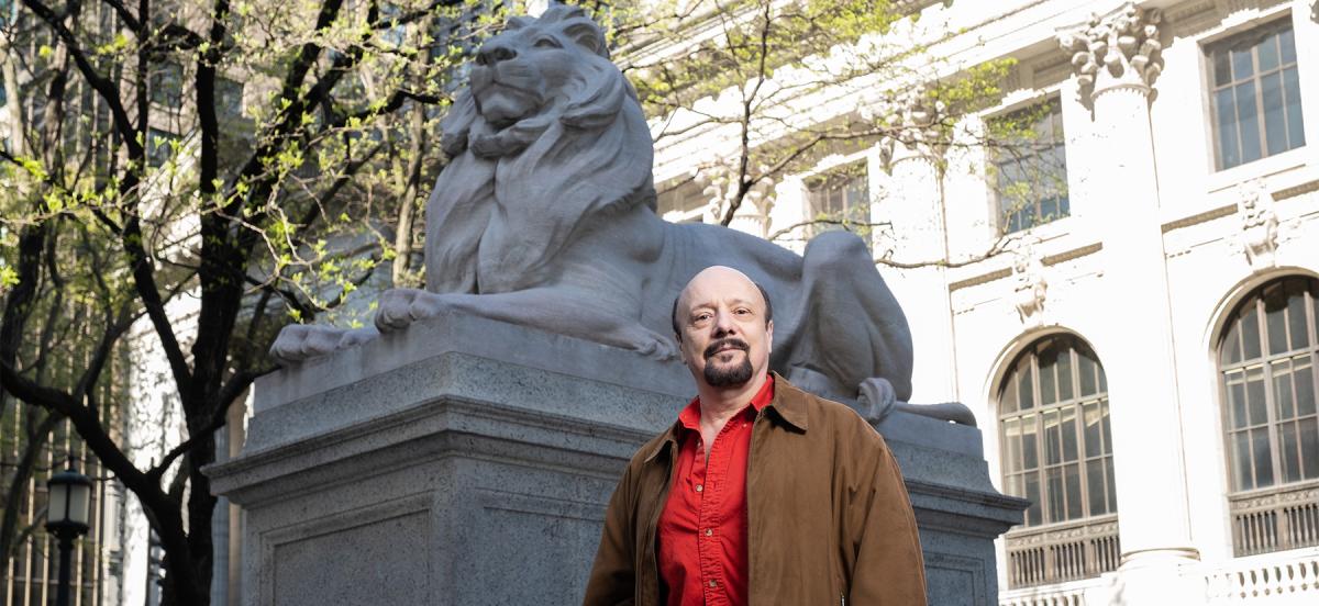Steven Pico '81 stands in front of one of the iconic lion statues at the New York Public Library.