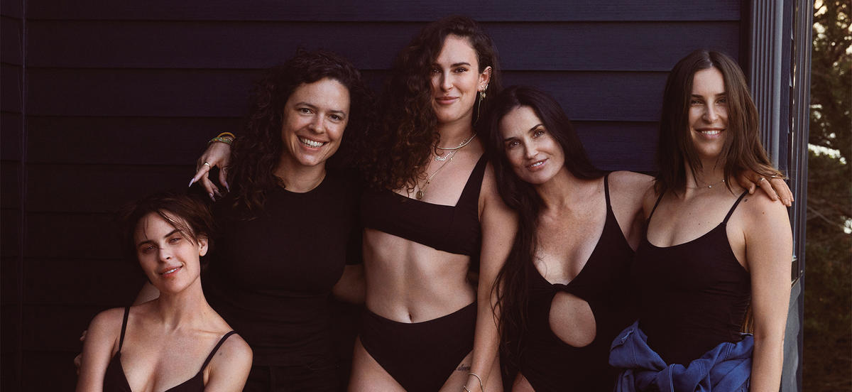 Melanie Travis '08 stands in front of a dark background with actress Demi Moore and her three daughters, who are wearing Andie produced swimwear.
