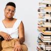 Denne Michele Norris sits in her home office next to bookshelves full of books. 